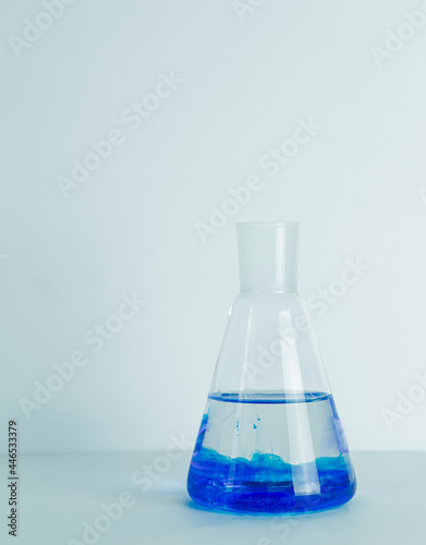 Laboratory glass Erlenmeyer conical flask filled with blue chemical liquid for a chemistry experiment in a science research lab,COPY SPACE