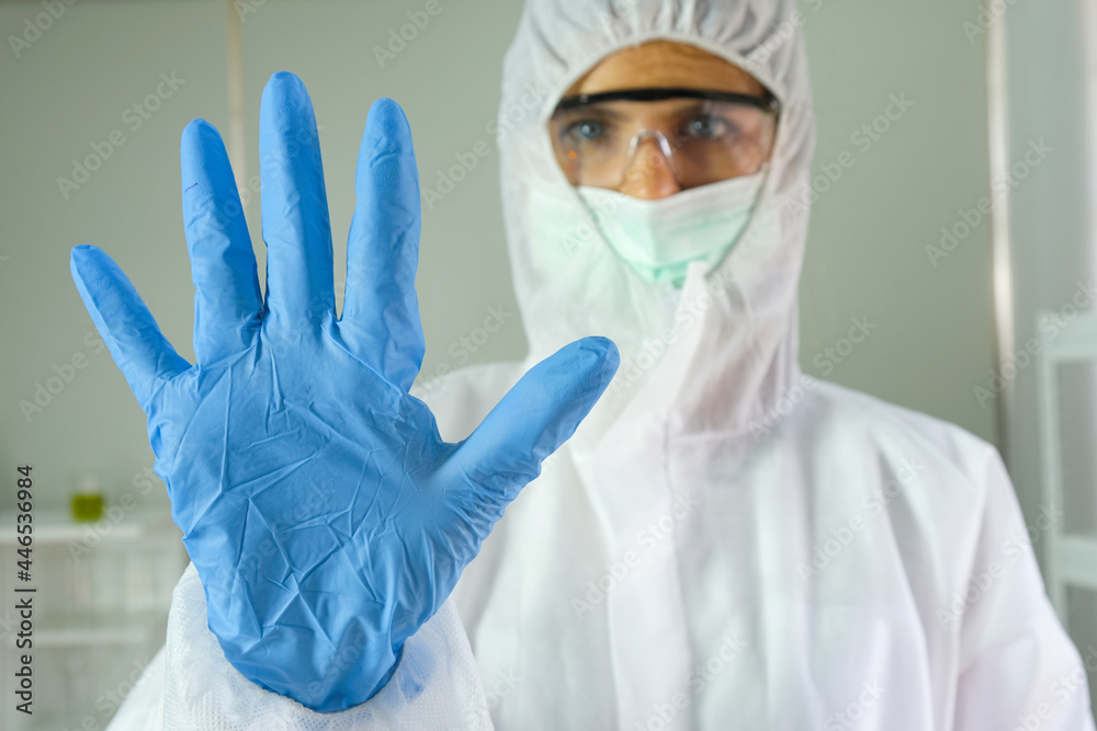 Doctor wore a protective gown from the coronavirus and he raised his hand to stop.Medical concepts Doctor wore a protective gown from the coronavirus and he raised his hand to stop.Medical concepts