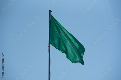 Green Flag in the Levante beach in Formentera, Spain in summer 2021.