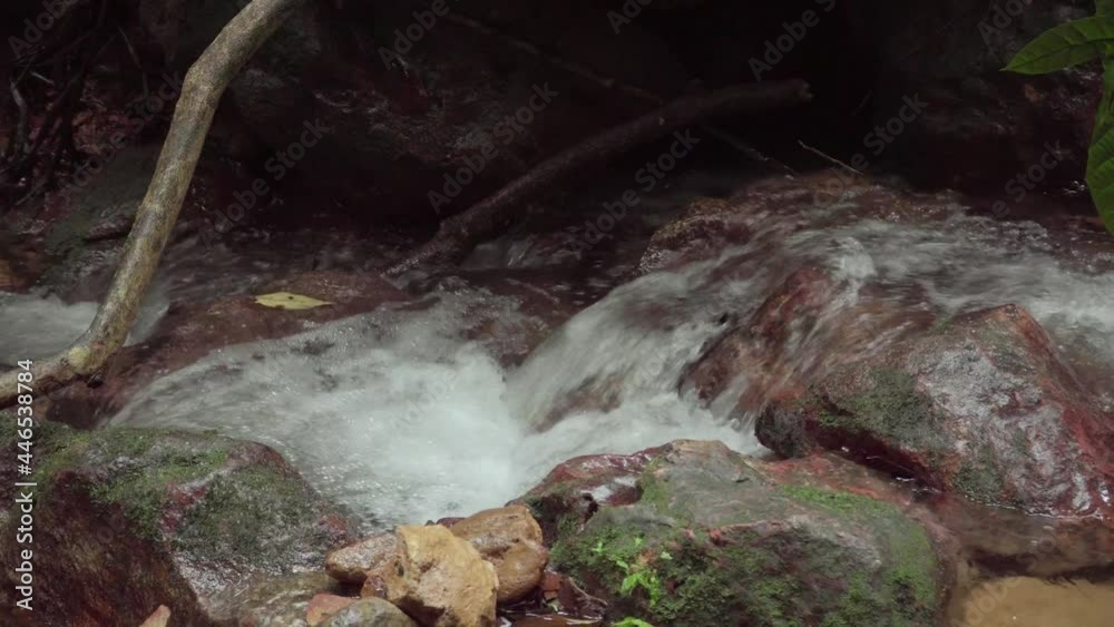 Mountain river in tropical rainforest. Rapid waterfall in creek. Peaceful stream flows over rocks and boulders in the wild jungle forest. Mountain river in tropical rainforest. Rapid waterfall in creek. Peaceful stream flows over rocks and boulders in the wild jungle forest.