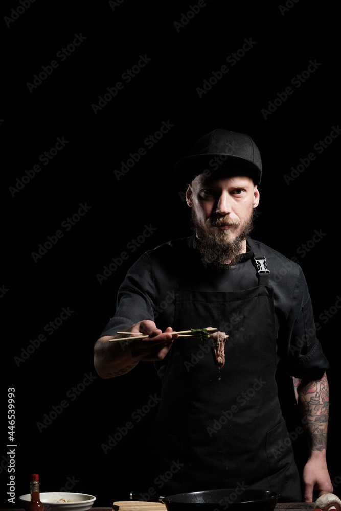 Chef tasting freshly made beef in chopsticks Chef tasting freshly made beef in chopsticks