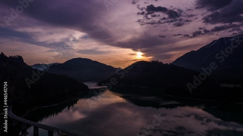 Beautiful Aerial Timelapse of the sunrise over the Sylvenstein Lake, Bavaria Germany. Clouds moving fast over a lake photo