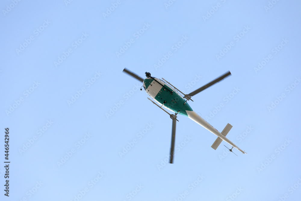 Fototapeta premium Helicopter with video surveillance system flying in blue sky. Takes video from sports competitions