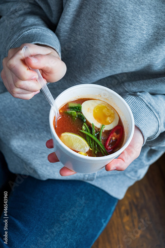 woman eating asian soup in cafe