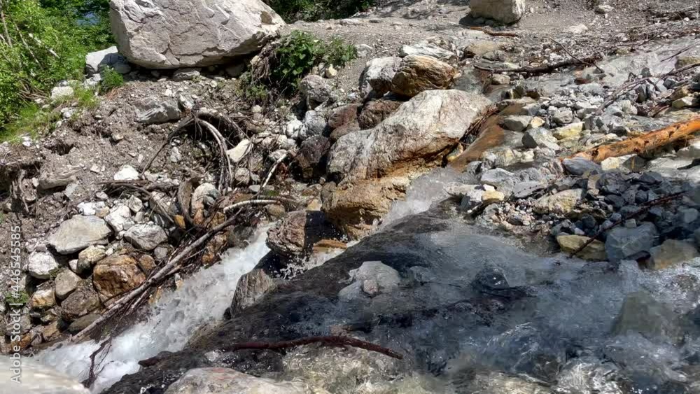 Slow motion shot of flowing fresh water stream down the rocks in nature, bee flying into camera Slow motion shot of flowing fresh water stream down the rocks in nature, bee flying into camera