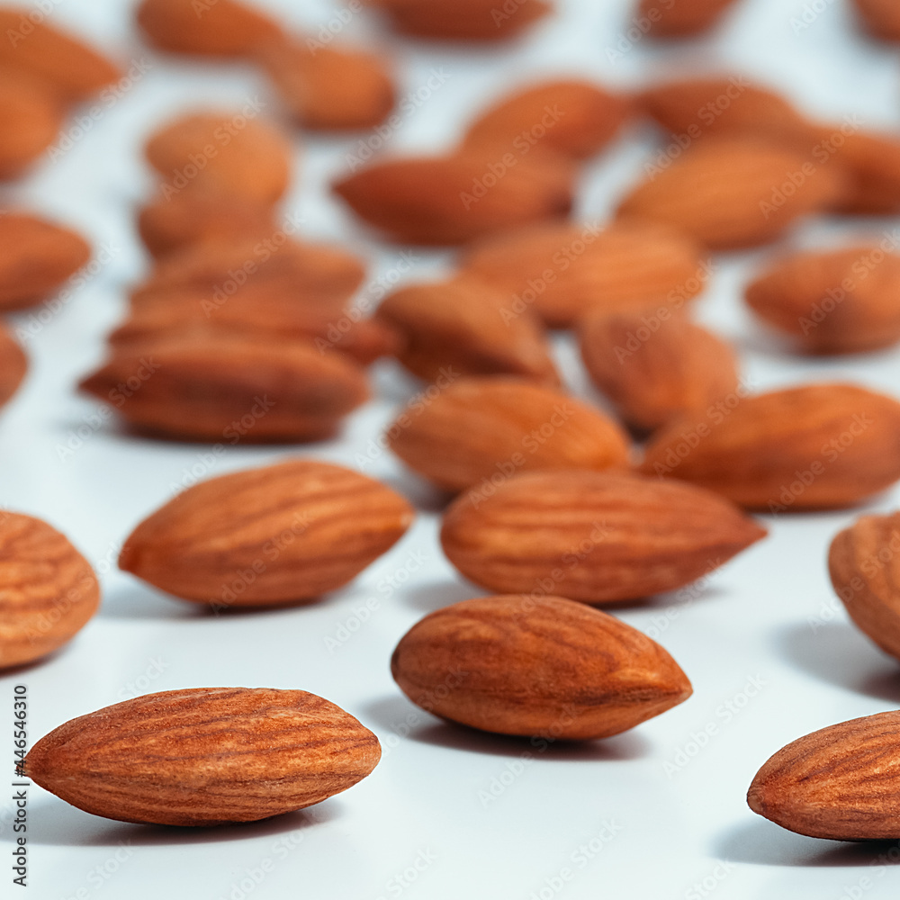 Background of almonds. Fried almonds. Scattered almond grains. Background for advertising Background of almonds. Fried almonds. Scattered almond grains. Background for advertising