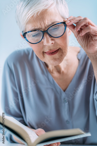 Glaucoma. Senior Woman a Reading Book, Having Ocular Tension.