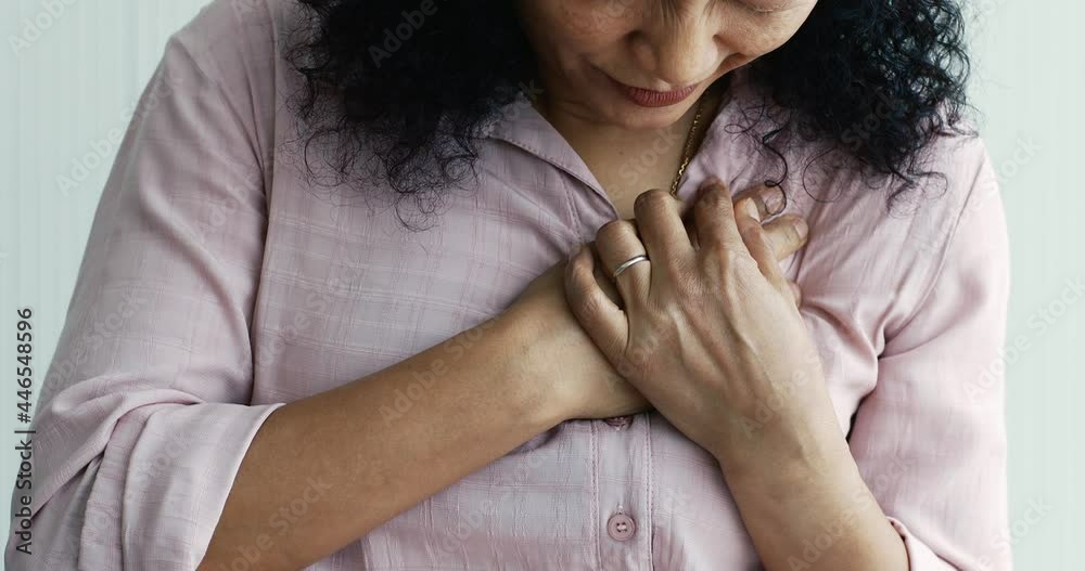 A senior Asian woman feels suffer and pain from headaches using her hand holding head. Concept of older person health care.