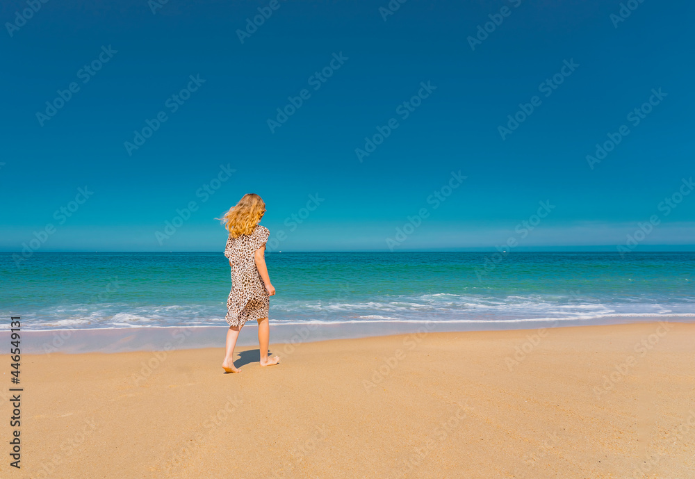Young beautiful girl in beige dress running on the the sandy beach near the waves. High quality photo Young beautiful girl in beige dress running on the the sandy beach near the waves. High quality photo
