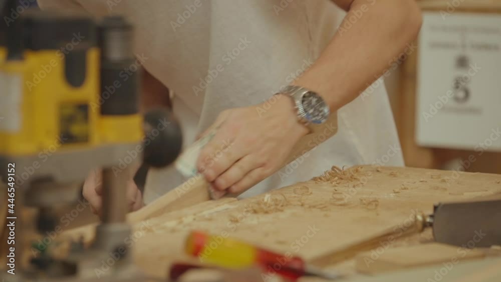 Focus on forearm of woodworker sanding a wooden list in carpentry workshop. Real Time Focus on forearm of woodworker sanding a wooden list in carpentry workshop. Real Time