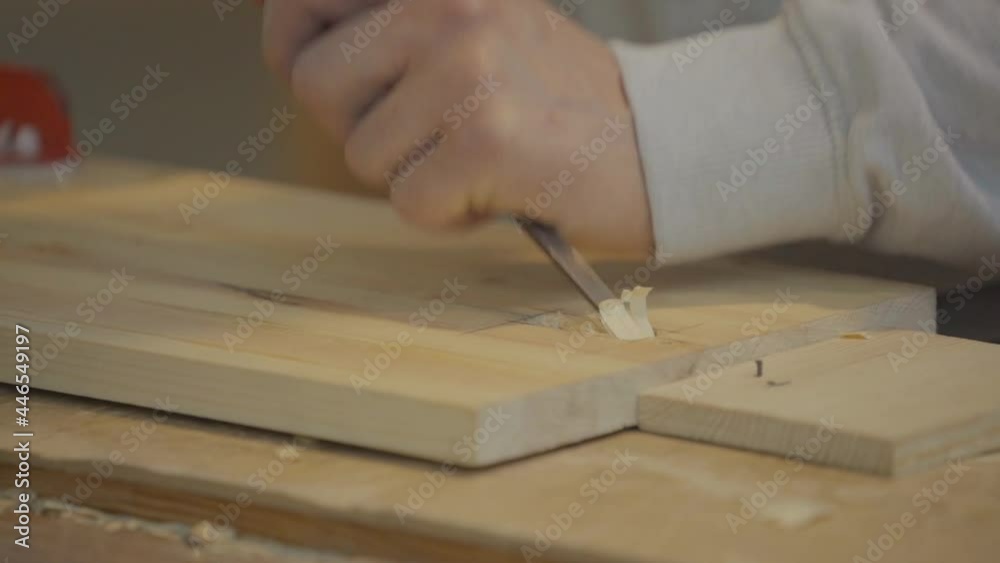 Close-up of hands with hammer and chisel carving a wooden board. Slow motion. Close-up of hands with hammer and chisel carving a wooden board. Slow motion.