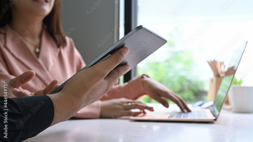 Cropped shot business people analyzing financial data on digital tablet together. Cropped shot business people analyzing financial data on digital tablet together.