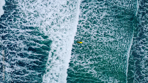 Lofoten, Norway in December: surfer with yellow board in the cold ocean