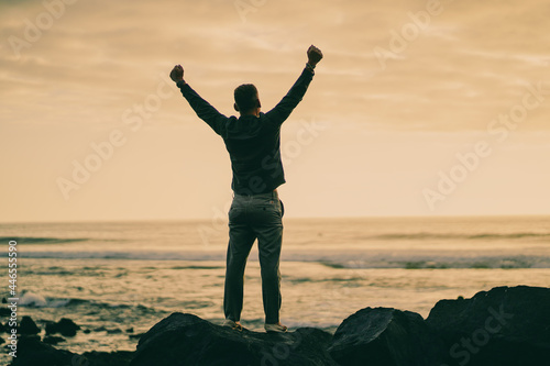 happy successful MAN  in YES POSE on beach rocks AT THE ocean WITH arms wide open enjoying life
 photo