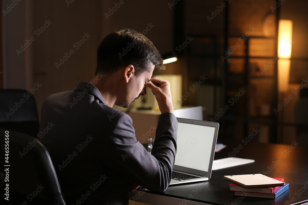 Tired businessman working in office late at night Tired businessman working in office late at night