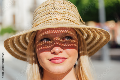Woman in straw hat on sunny day in city photo