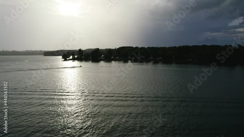 Aerial view of Lake with shiny water and green trees. Sun reflection in the water. Beautiful spring landscape with trees photo