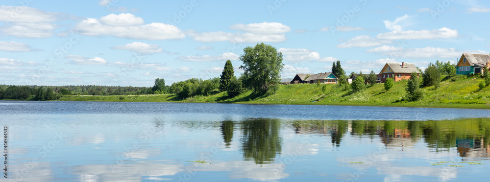 Fototapeta premium Beautiful rural landscape. Small village by the lake on a sunny summer day.