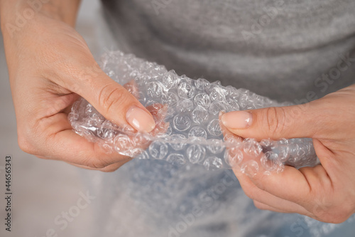 The faceless woman bursts the packaging bubbles. Antistress