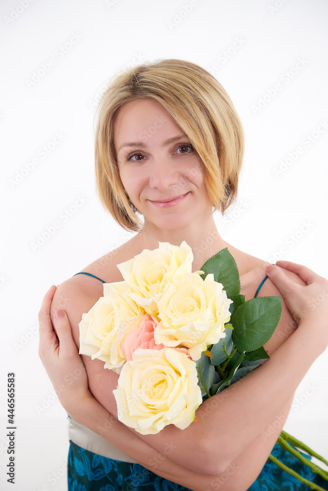 Pretty skinny girl with beautiful flowers on a white background in photo studio Pretty skinny girl with beautiful flowers on a white background in photo studio