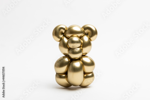 A cute little bear made from a 260 magic balloon with a Reflex gold color on a white background. photo