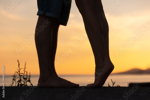 Silhouette of a couple kissing. Legs close-up. Sunset in the background. Valentines day concept