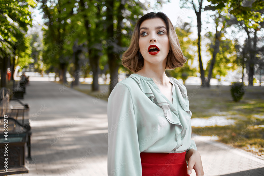 pretty blonde in red skirt outdoors in the park green trees pretty blonde in red skirt outdoors in the park green trees