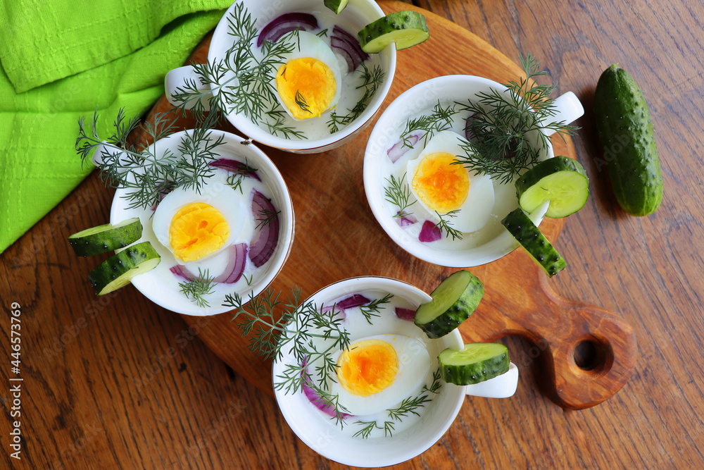 Cold soup with cucumbers, yogurt, eggs and fresh herbs on the wooden rustic table Cold soup with cucumbers, yogurt, eggs and fresh herbs on the wooden rustic table