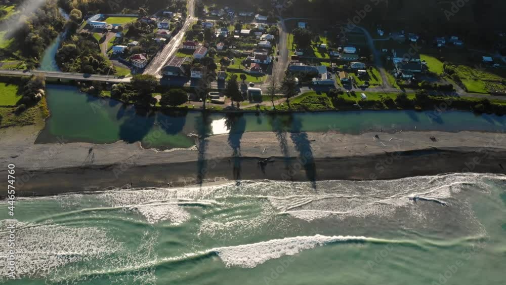 Isolated community on beachside, East Coast of New Zealand. Houses, the river and sandy beach. Tokomaru Bay - aerial
