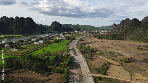 drone shot of road divide contrast rice field half green half harvested photo