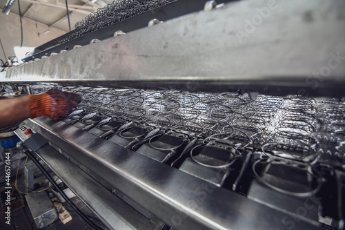 Production of metal wire springs for matresses. Selective focus. photo