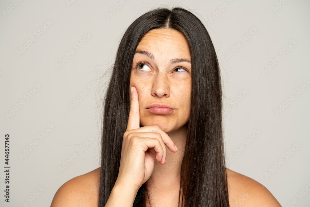 A young woman thinks suspiciously and looks up A young woman thinks suspiciously and looks up