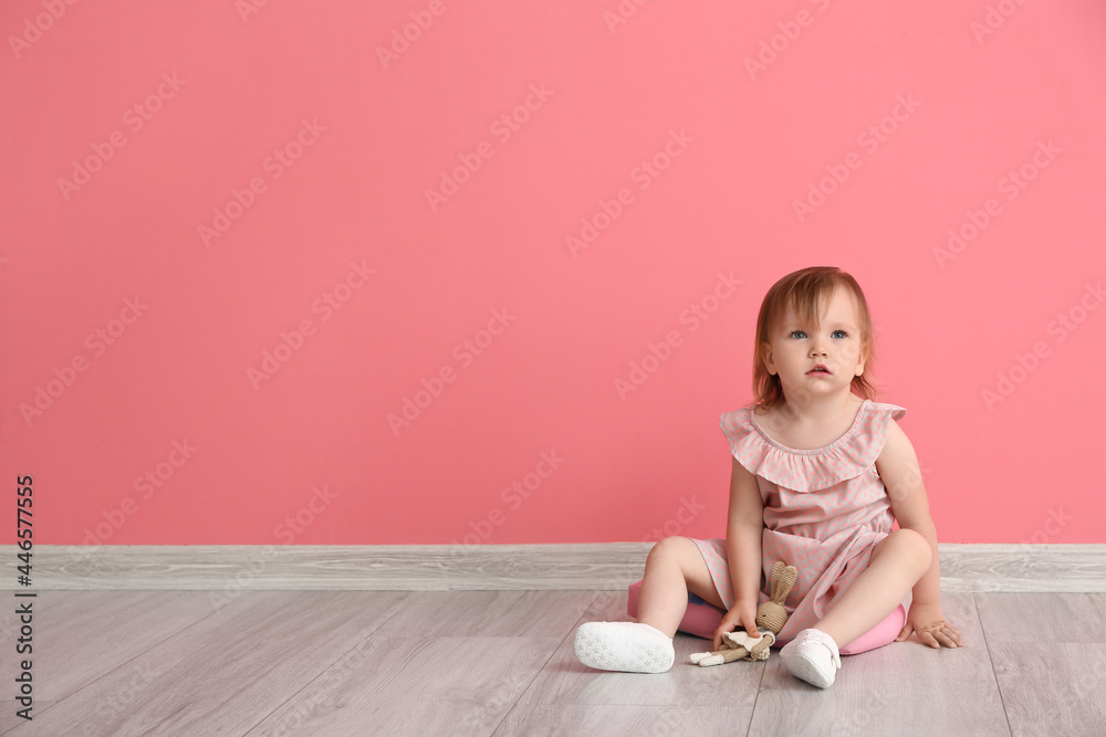 Cute baby girl sitting near color wall Cute baby girl sitting near color wall