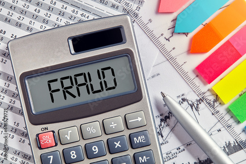 Fotografia Office desktop with calculator displaying the word fraud