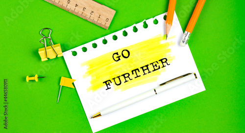 Text GO FURTHER sign showing on green background with office tools