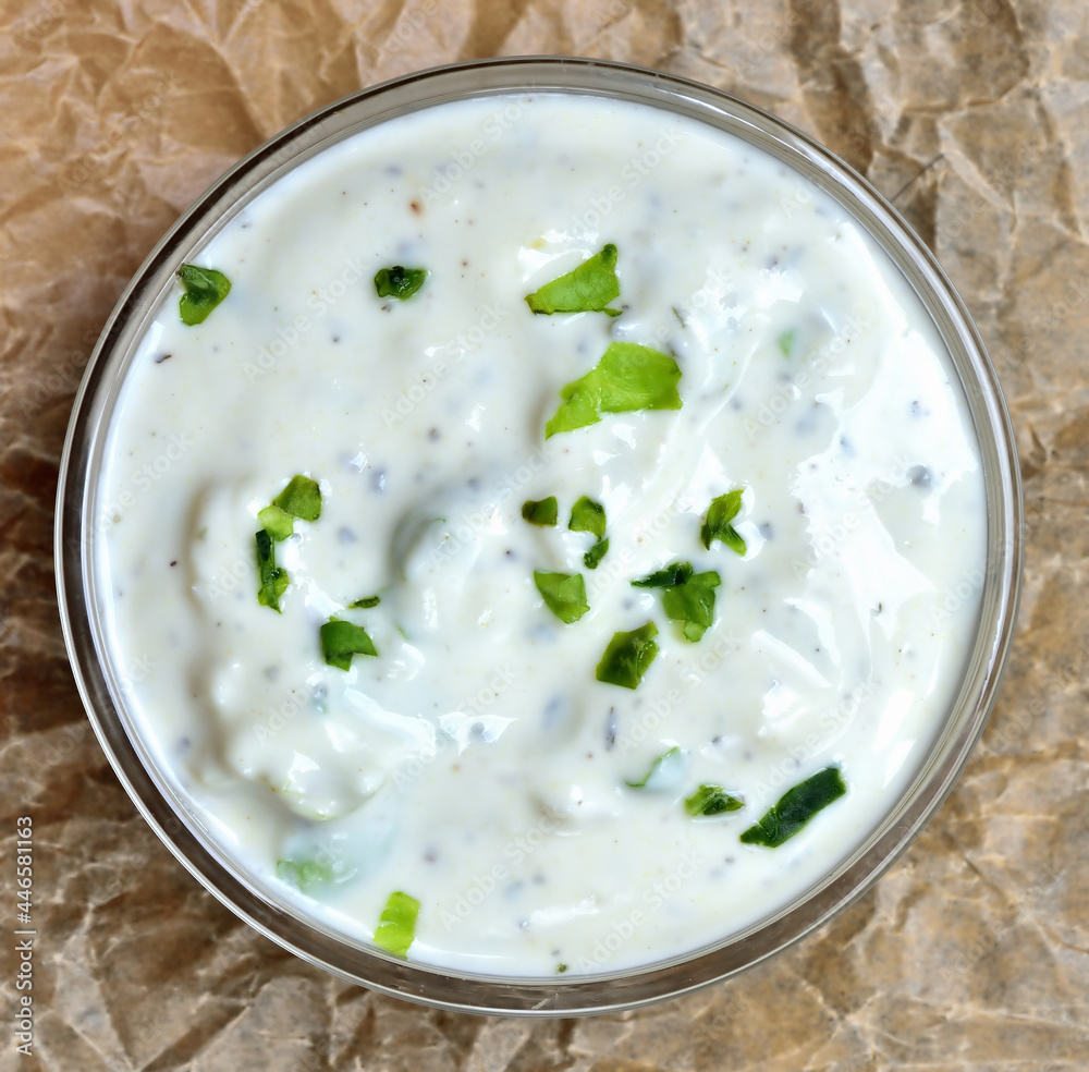 Homemade garlic yogurt dip sauce with herbs. View from top.