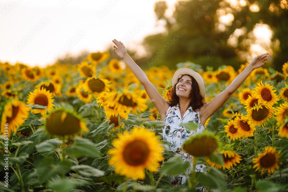Young woman strolling through field with sunflowers at sunset. Carefree woman walking and enjoying beautiful nature environment. Summer holidays, vacation, relax and lifestyle. Young woman strolling through field with sunflowers at sunset. Carefree woman walking and enjoying beautiful nature environment. Summer holidays, vacation, relax and lifestyle.