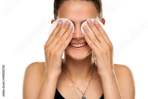 Fotografie smiling teen girl cleans her face with cotton pads