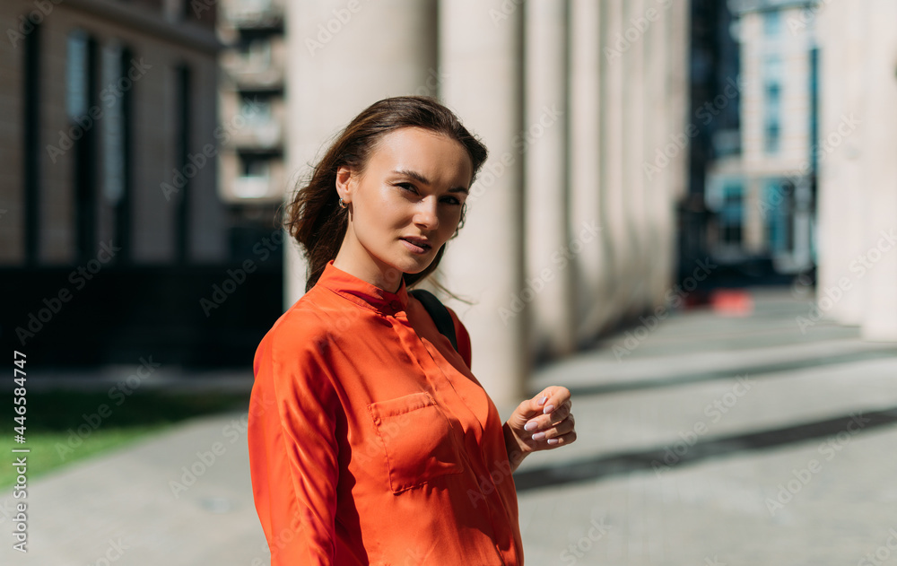 Fototapeta premium Beautiful girl model posing at camera in the summer city in the sun