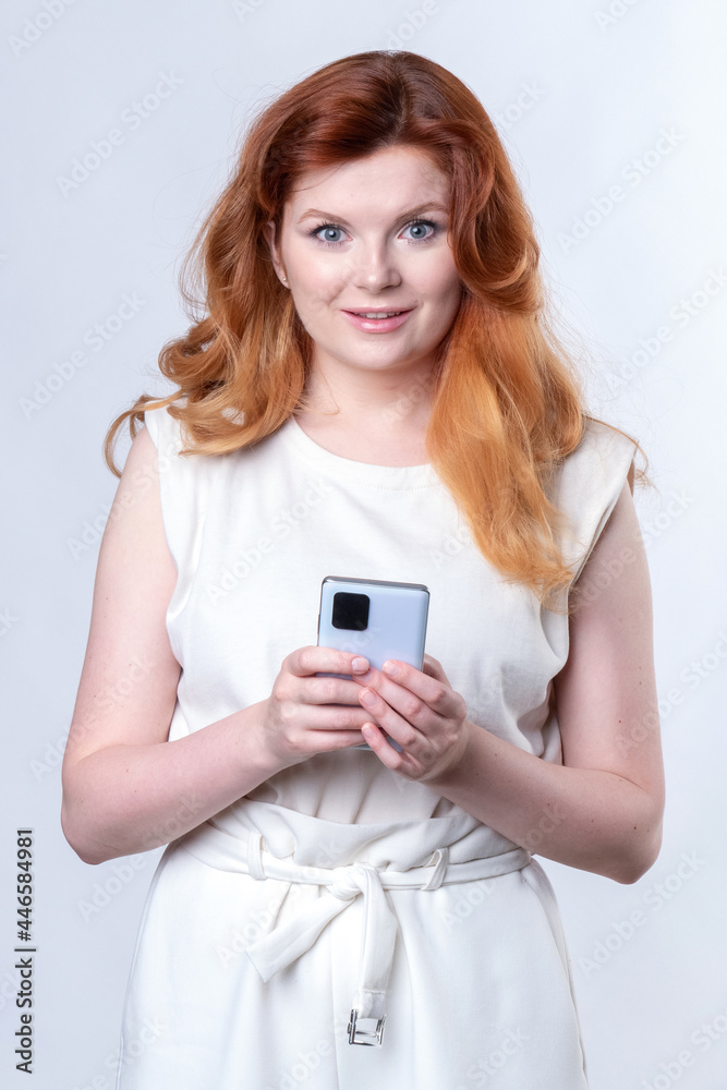 Redhead woman with a large smartphone in her hands Redhead woman with a large smartphone in her hands