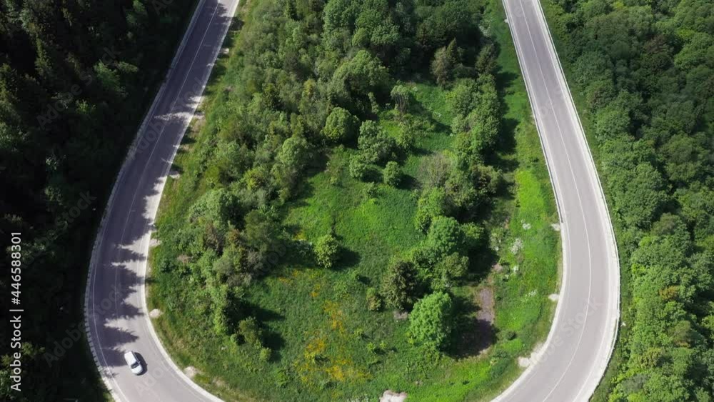 Flight over the summer mountains with mountain road serpentine