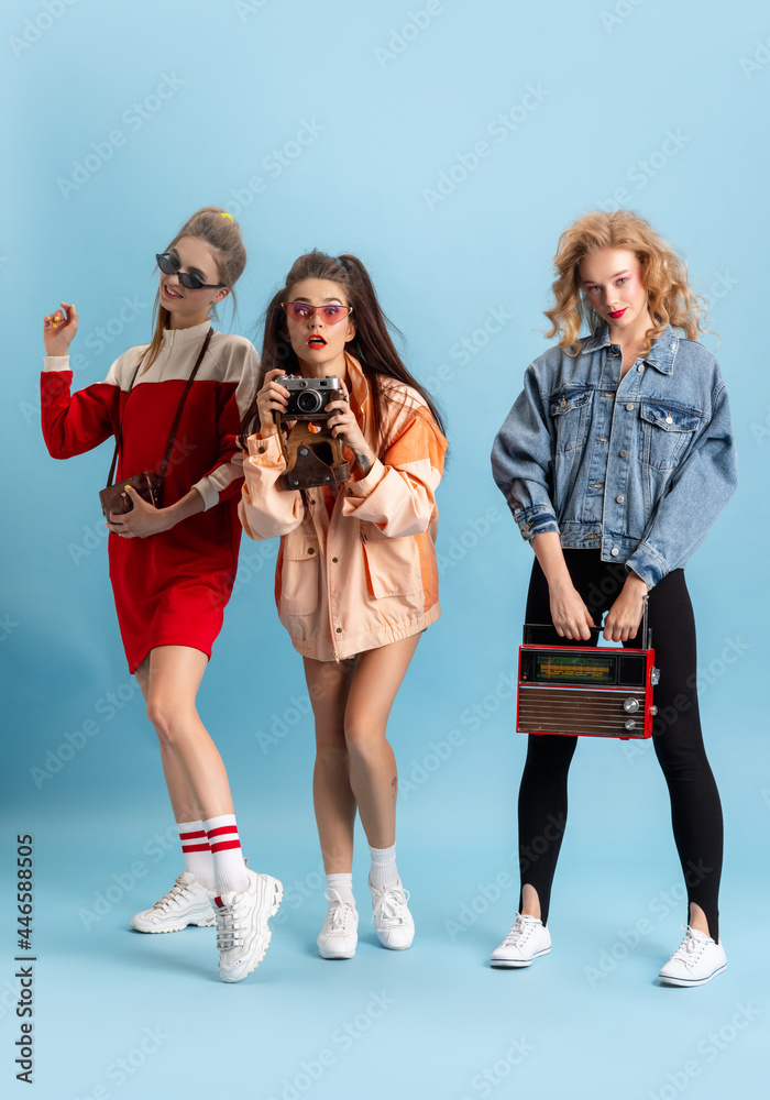 Pretty young women in retro 90s fashion style, outfits posing isolated over  blue studio background. Concept of eras comparison, beauty, fashion and  youth. Stock Photo | Adobe Stock