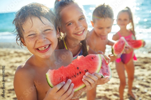 Children with a watermelon at the sea. A group of children have fun playing at the sea. High quality photo photo