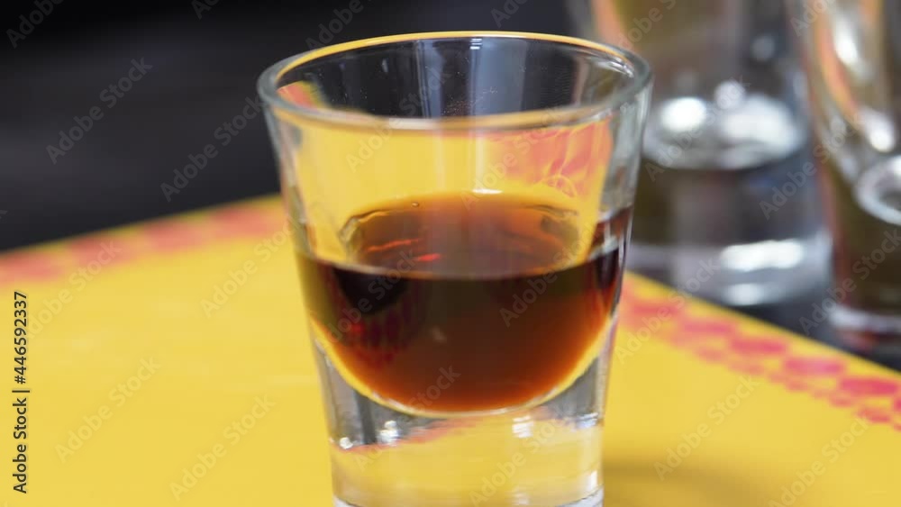 Bartender Pouring Brown Liquor in a Shot Glass Preparing A B-52 Cocktail Shot. - Closeup Shot Bartender Pouring Brown Liquor in a Shot Glass Preparing A B-52 Cocktail Shot. - Closeup Shot