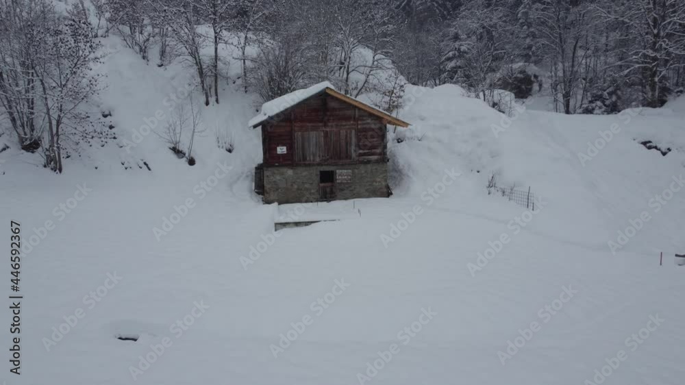 A snowy barn in winter. It is snowing and everything is covered with snow. The stable is in the Swiss Alps. Winter atmosphere A snowy barn in winter. It is snowing and everything is covered with snow. The stable is in the Swiss Alps. Winter atmosphere