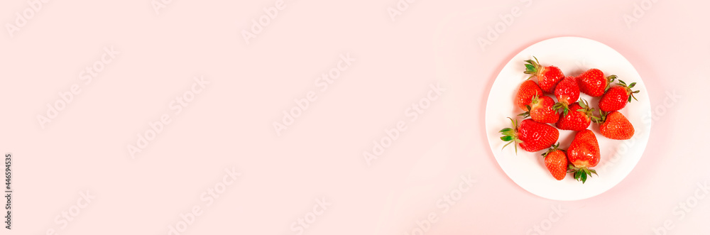 Top view strawberry on white plate on a pink background. horizontal space for text Top view strawberry on white plate on a pink background. horizontal space for text