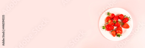 Top view strawberry on white plate on a pink background. horizontal space for text
