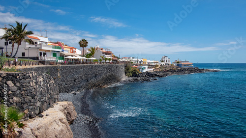 Charming little coastal resort in the south of the island with large promenade lined up with fish restaurants, terraces and bars in La Caleta, Costa Adeje, Tenerife, Canary Islands, Spain photo