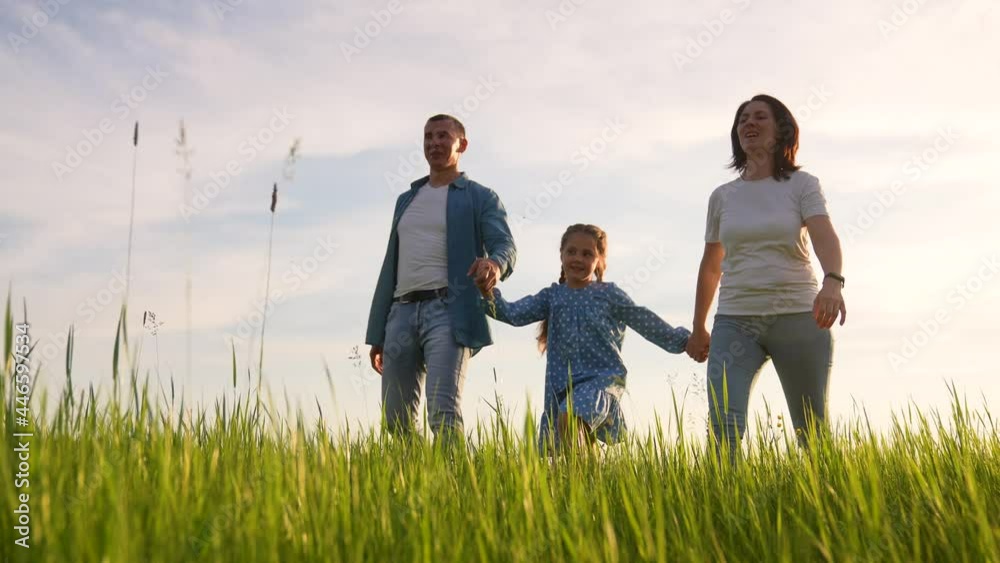 Happy cute family. Happy dream people in park. Parents and daughter hiking on green grass. Concept of happy family. Parents and daughter walk on green grass. Family hiking. Dream baby in park Happy cute family. Happy dream people in park. Parents and daughter hiking on green grass. Concept of happy family. Parents and daughter walk on green grass. Family hiking. Dream baby in park