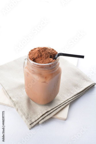 cold iced chocolate milo dinosaur with coco powder in glass jar white background asian beverage halal menu